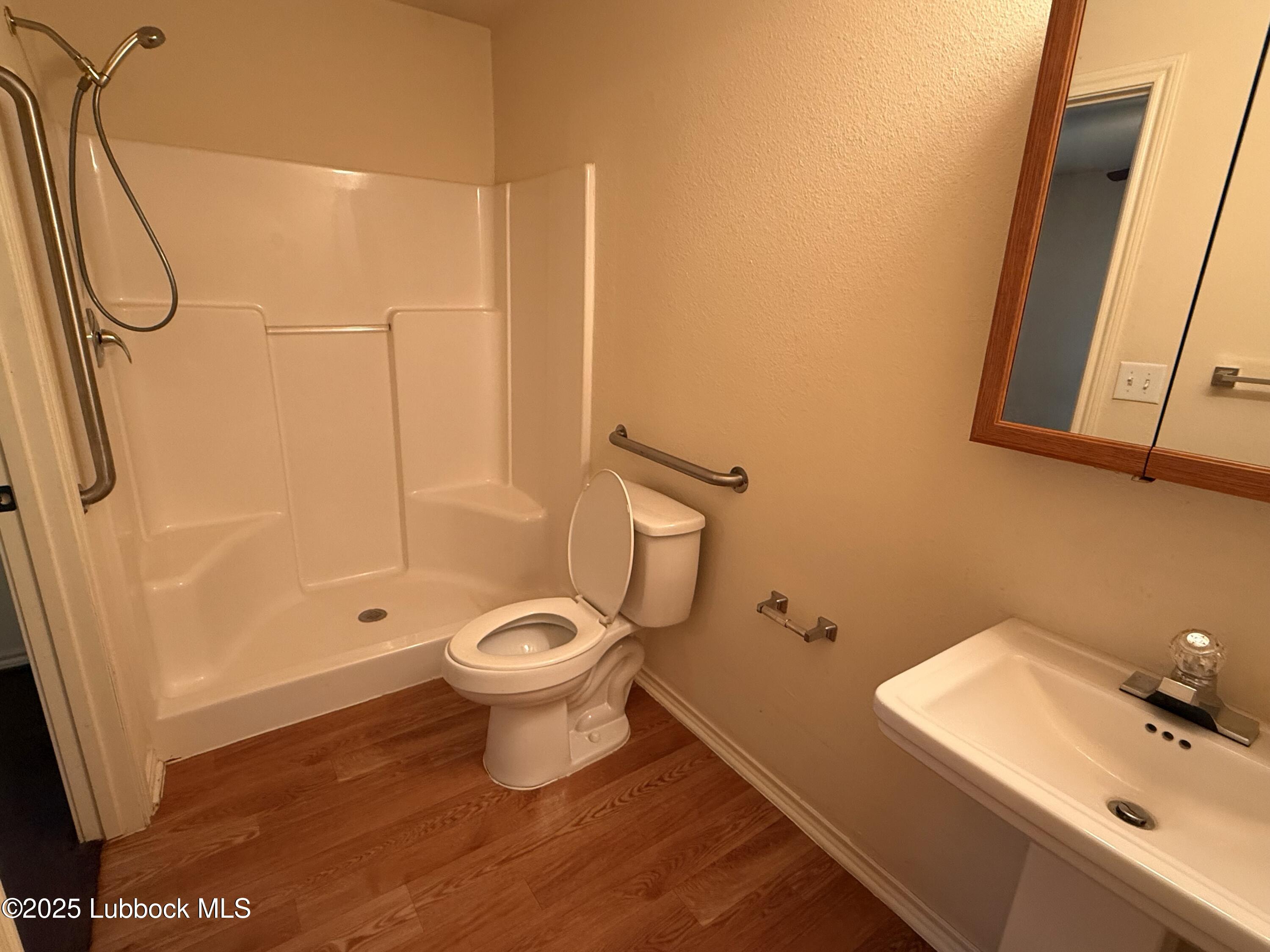 307 East 3rd Street Muleshoe, TX 79347 - Photo 18 of 20 a bathroom with a toilet sink and shower