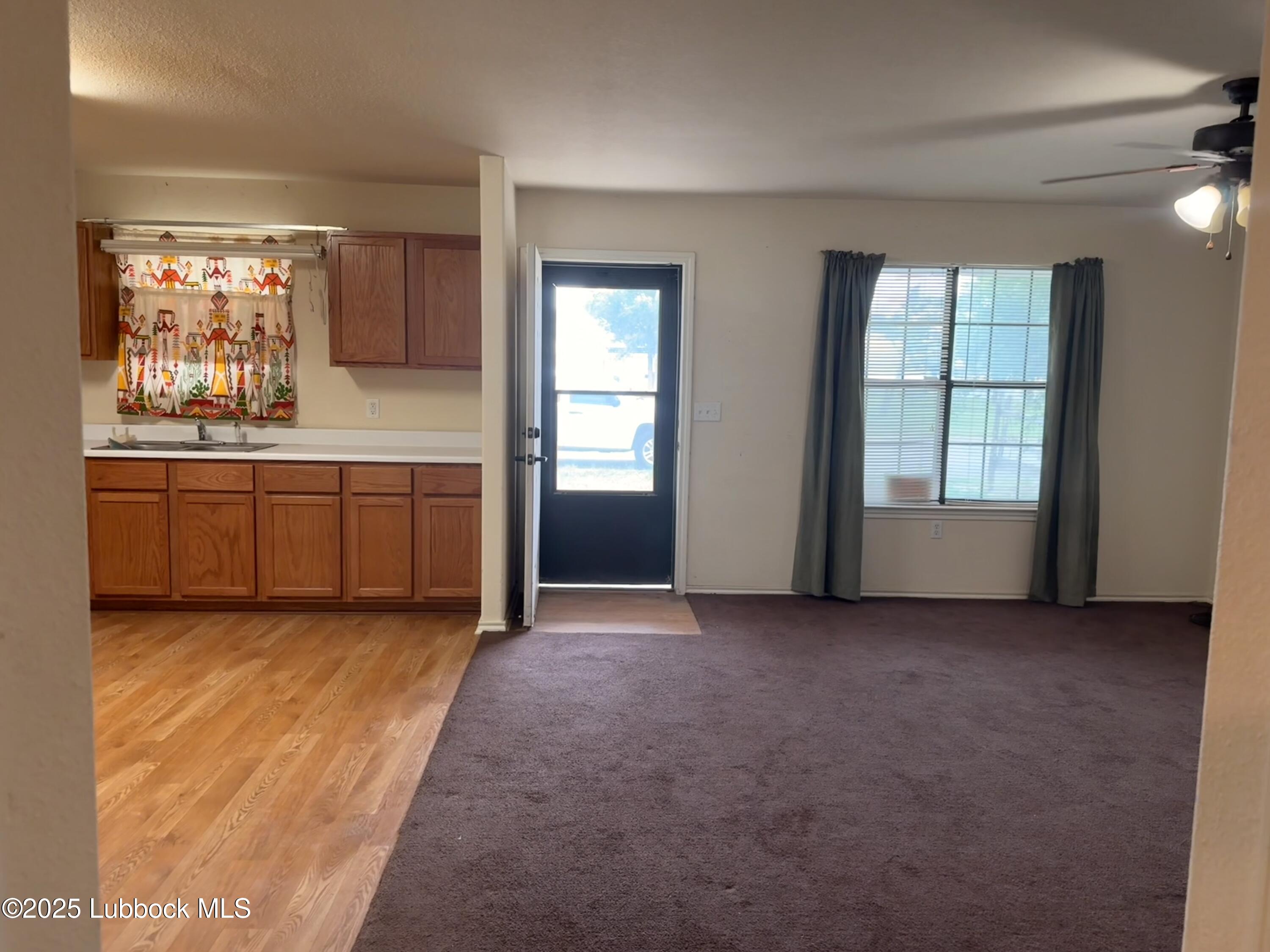 307 East 3rd Street Muleshoe, TX 79347 - Photo 4 of 20 a view of an empty room with window and kitchen area