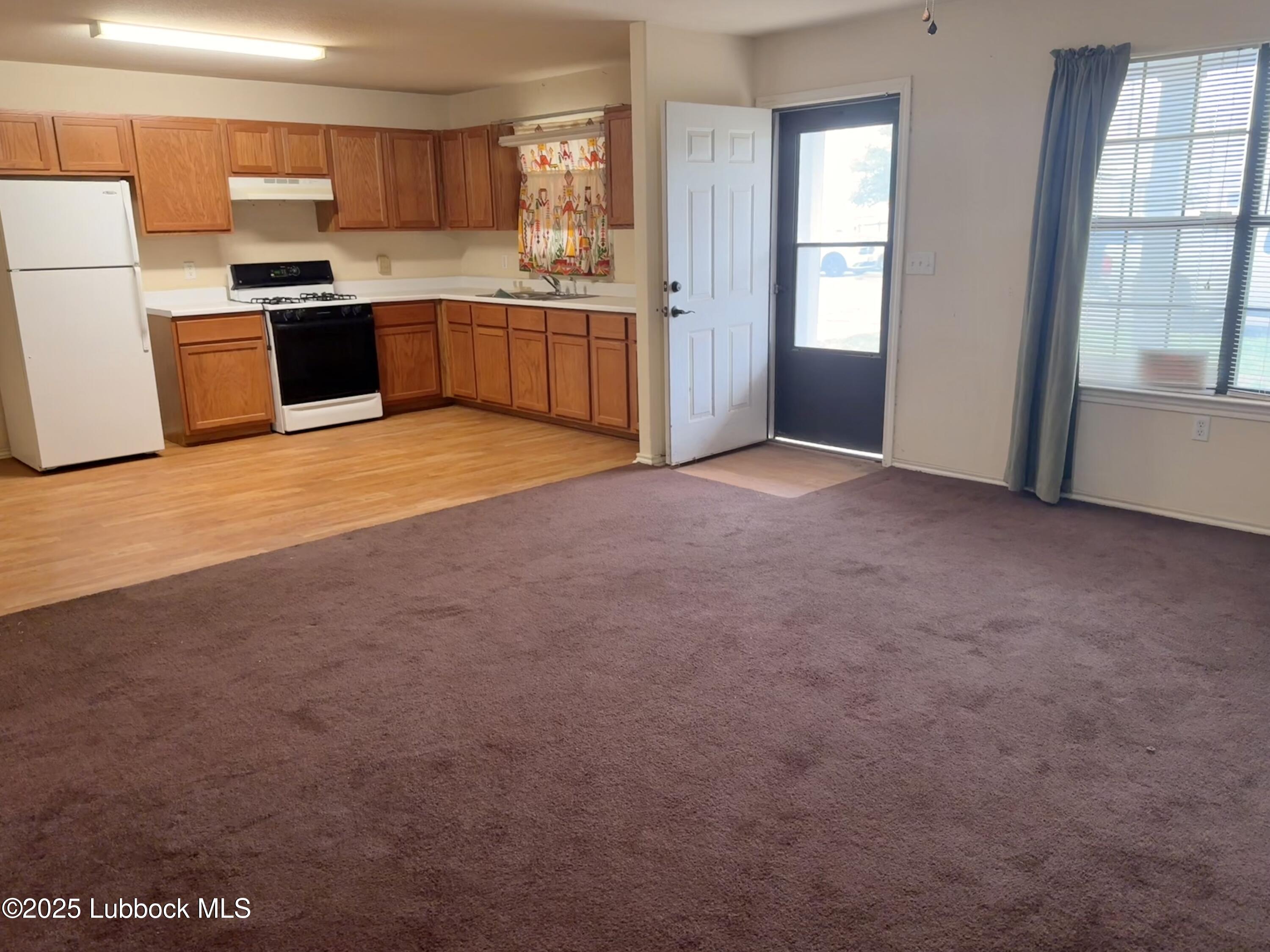 307 East 3rd Street Muleshoe, TX 79347 - Photo 5 of 20 a large kitchen with a refrigerator and a stove top oven