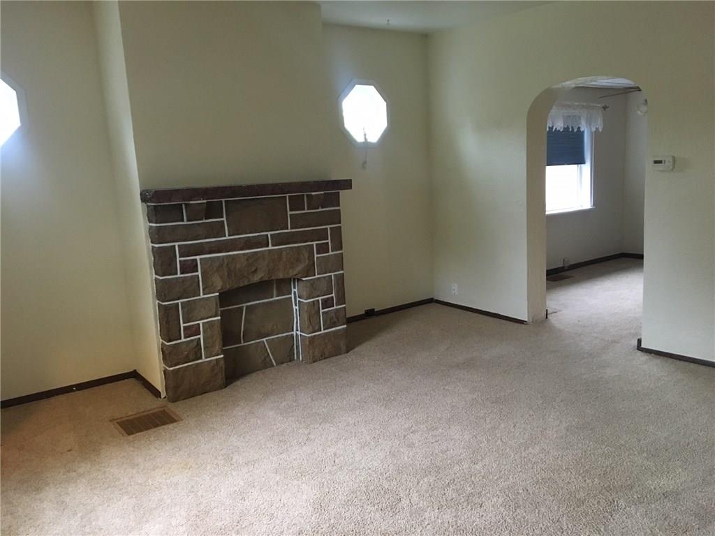 115 Lindsay Road Carnegie, PA 15106 - Photo 3 of 18 Living Room and Dining Room feature Neutral Plush carpet. Living Room with Updated Windows and Decorative Stone Fireplace.