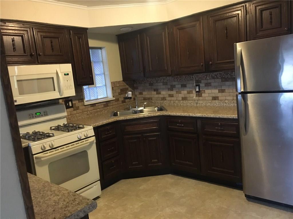 115 Lindsay Road Carnegie, PA 15106 - Photo 7 of 18 Fully Equipped Kitchen with newly updated Countertop and Tile Backsplash. All appliances are included. Double Stainless sink and Neutral Flooring also featured.