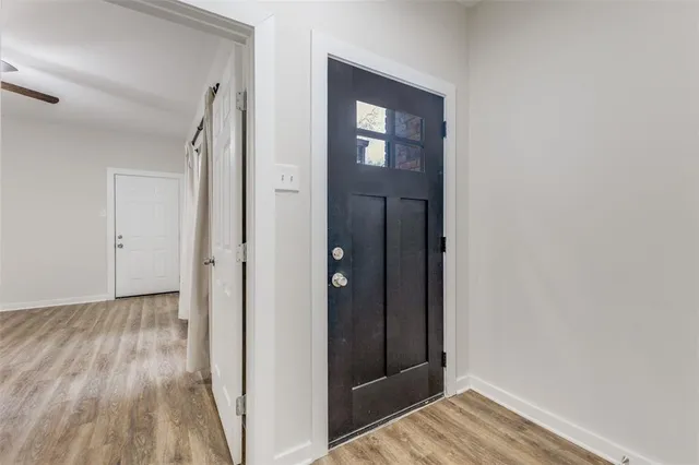 a view of a hallway with wooden floor and closet