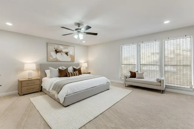 a spacious bedroom with a bed a couch and a large window