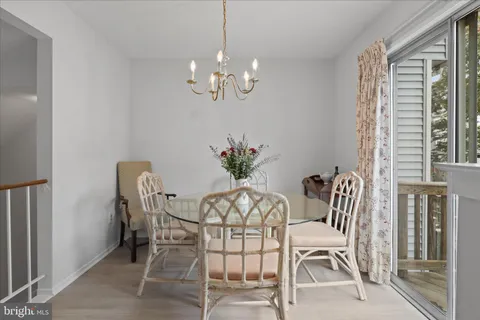 a dining room with furniture a chandelier and kitchen view