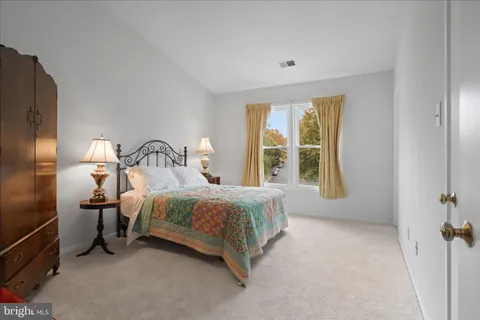 a bedroom with a bed lamp and a large window