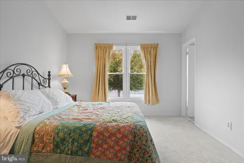 a bedroom with a bed and a large window