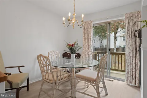 a view of a dining room with furniture a chandelier and wooden floor