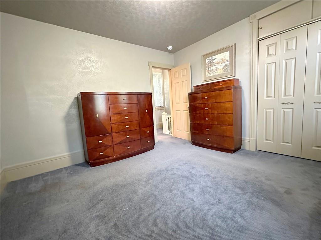 341 Kramer Way Pittsburgh, PA 15211 - Photo 23 of 37 The master closet is both practical and stylish, organized with ample storage above it. The handles on the closet doors are made of designer burnished brass, adding a touch of elegance. The floor is covered in deep, pristine charcoal wall-to-wall carpeting, which is well-padded for comfort. This combination of features creates a serene and inviting master bedroom, a true haven for sleep and relaxation.