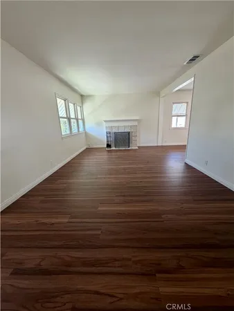 a view of empty room with window and wooden floor