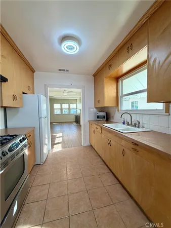a large kitchen with a stove a sink dishwasher and a refrigerator