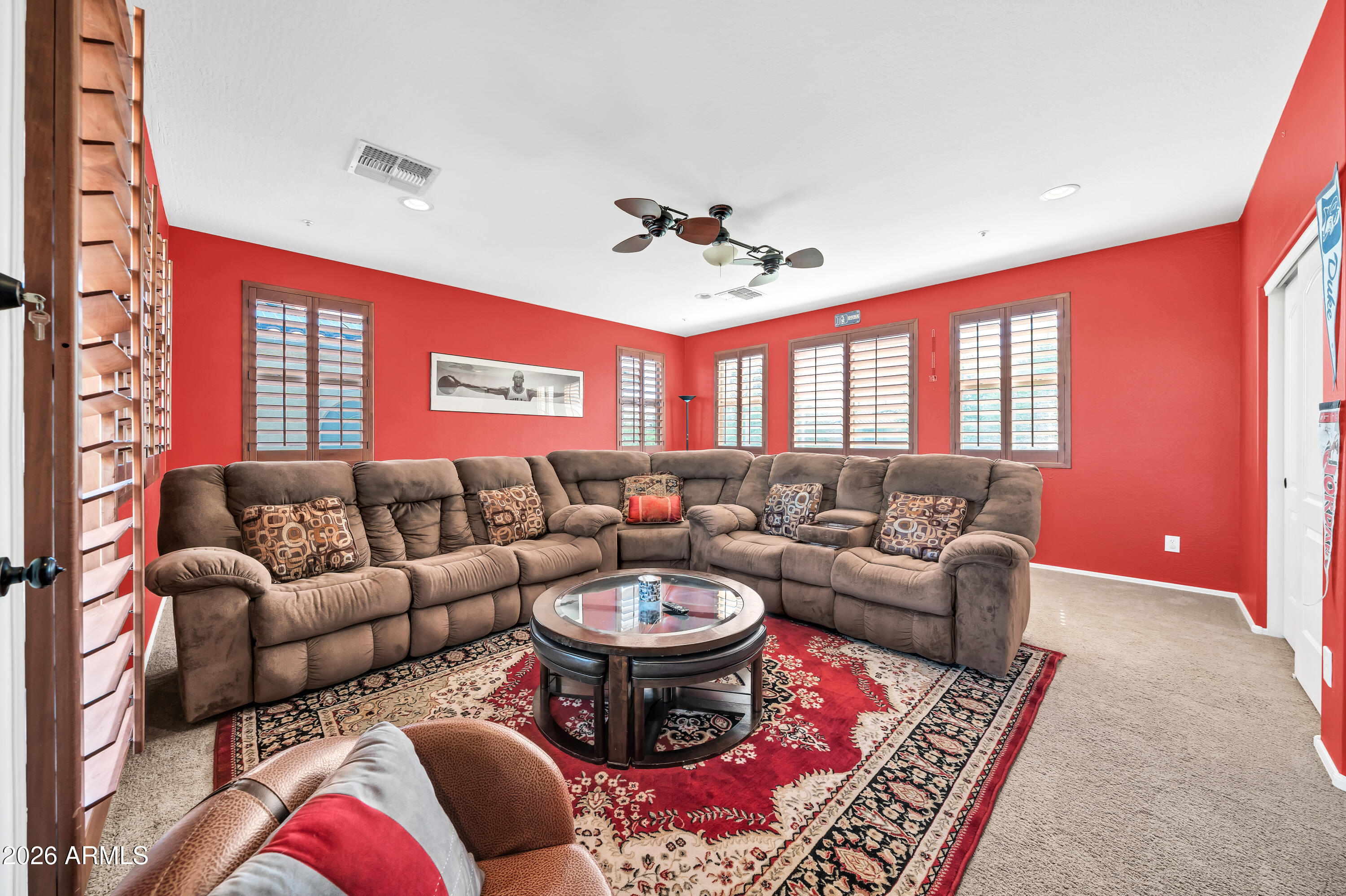 15327 West Roma Avenue Goodyear, AZ 85395 - Photo 8 of 65 a living room with furniture a rug and a chandelier