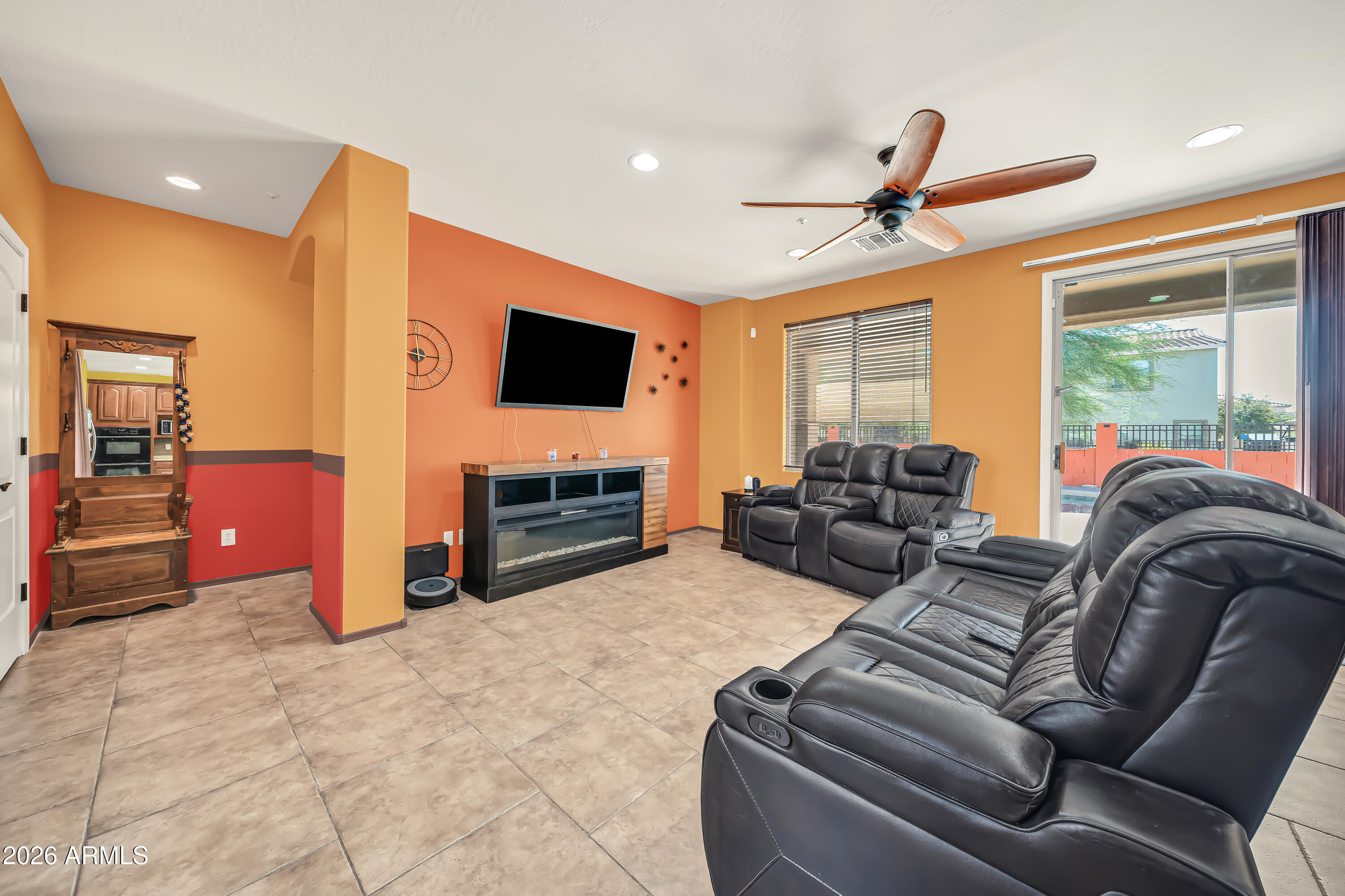 15327 West Roma Avenue Goodyear, AZ 85395 - Photo 15 of 65 a living room with furniture a flat screen tv and a fireplace