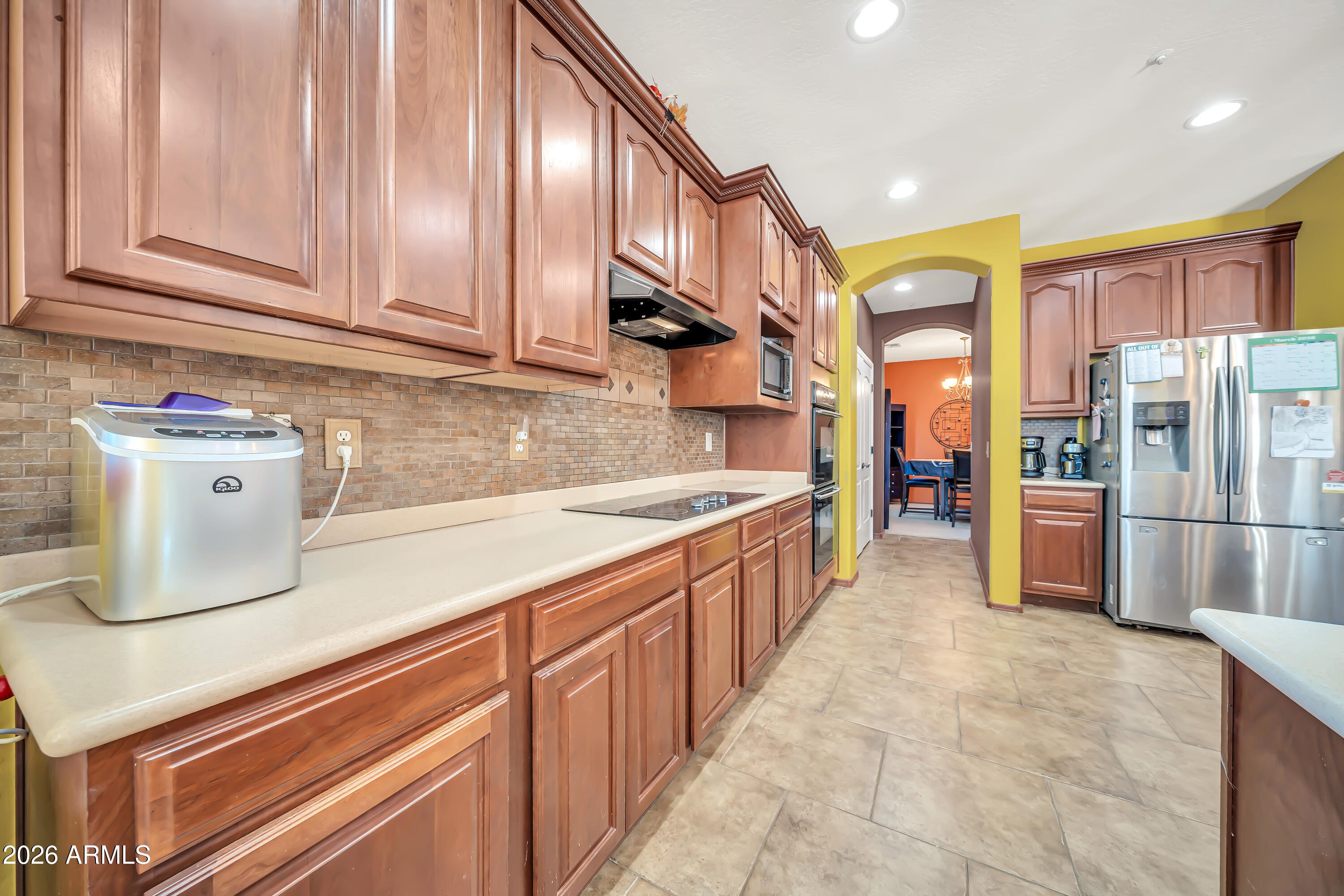 15327 West Roma Avenue Goodyear, AZ 85395 - Photo 20 of 65 a kitchen with stainless steel appliances granite countertop a refrigerator and a stove top oven