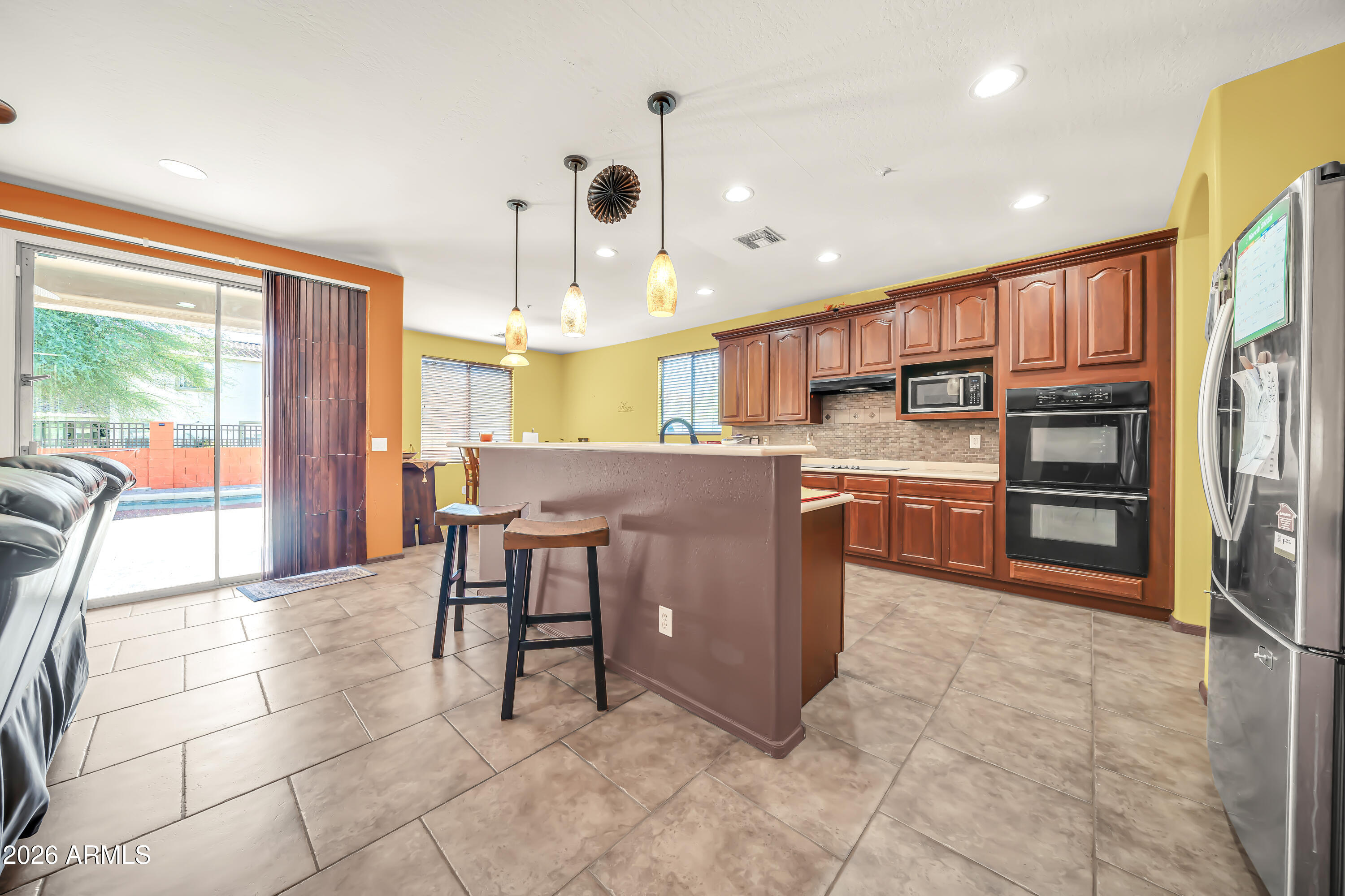 15327 West Roma Avenue Goodyear, AZ 85395 - Photo 24 of 65 a open kitchen with stainless steel appliances granite countertop a stove top oven a sink dishwasher and cabinets