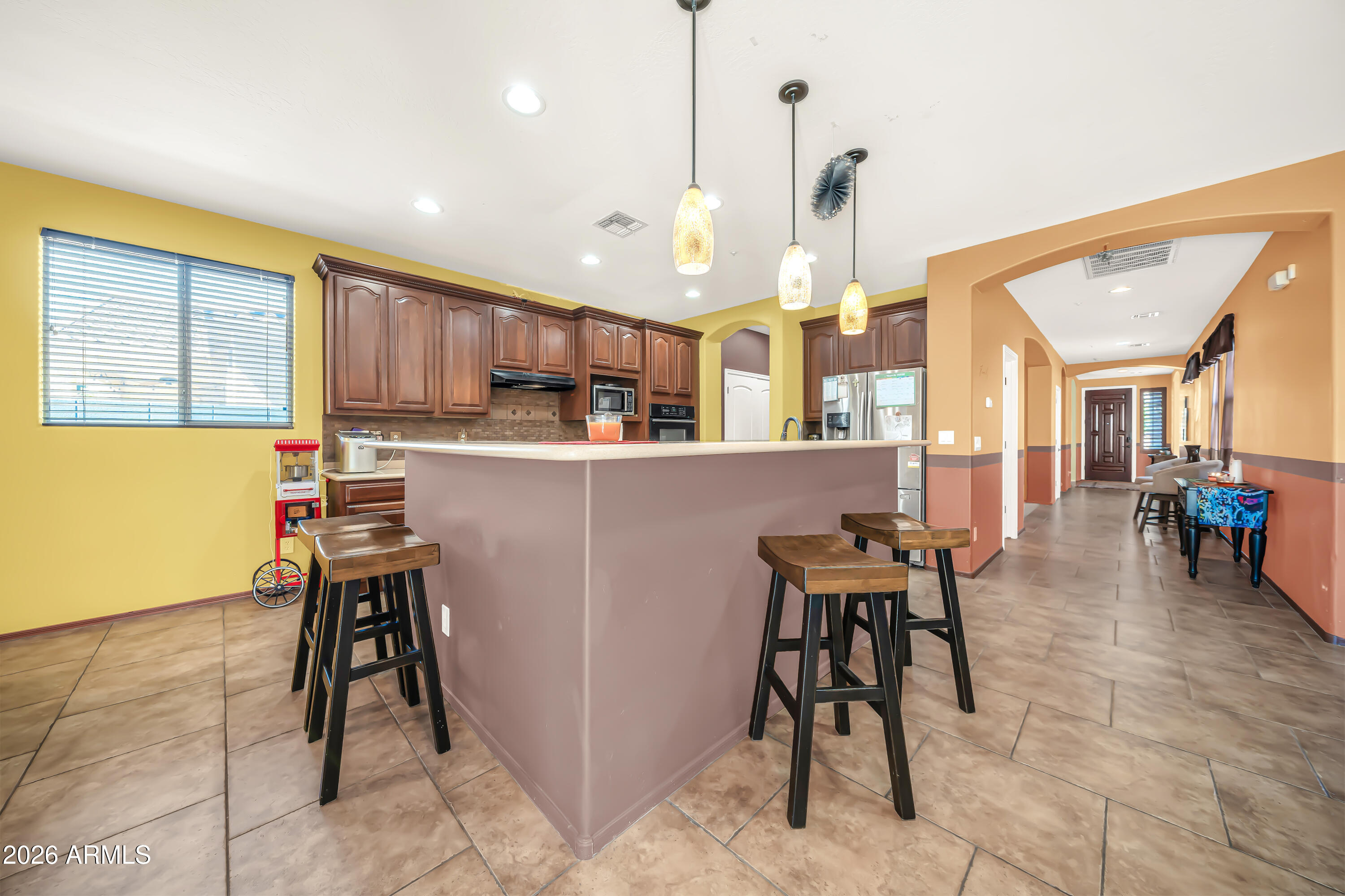 15327 West Roma Avenue Goodyear, AZ 85395 - Photo 25 of 65 a living room with stainless steel appliances kitchen island granite countertop furniture and a dining table
