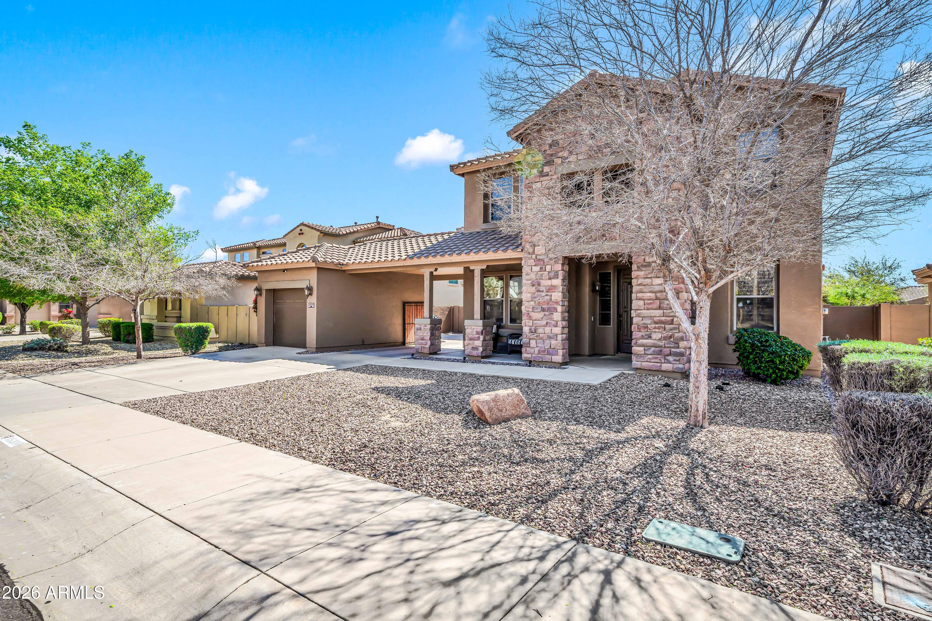15327 West Roma Avenue Goodyear, AZ 85395 - Photo 2 of 65 a front view of a house with a garden and patio