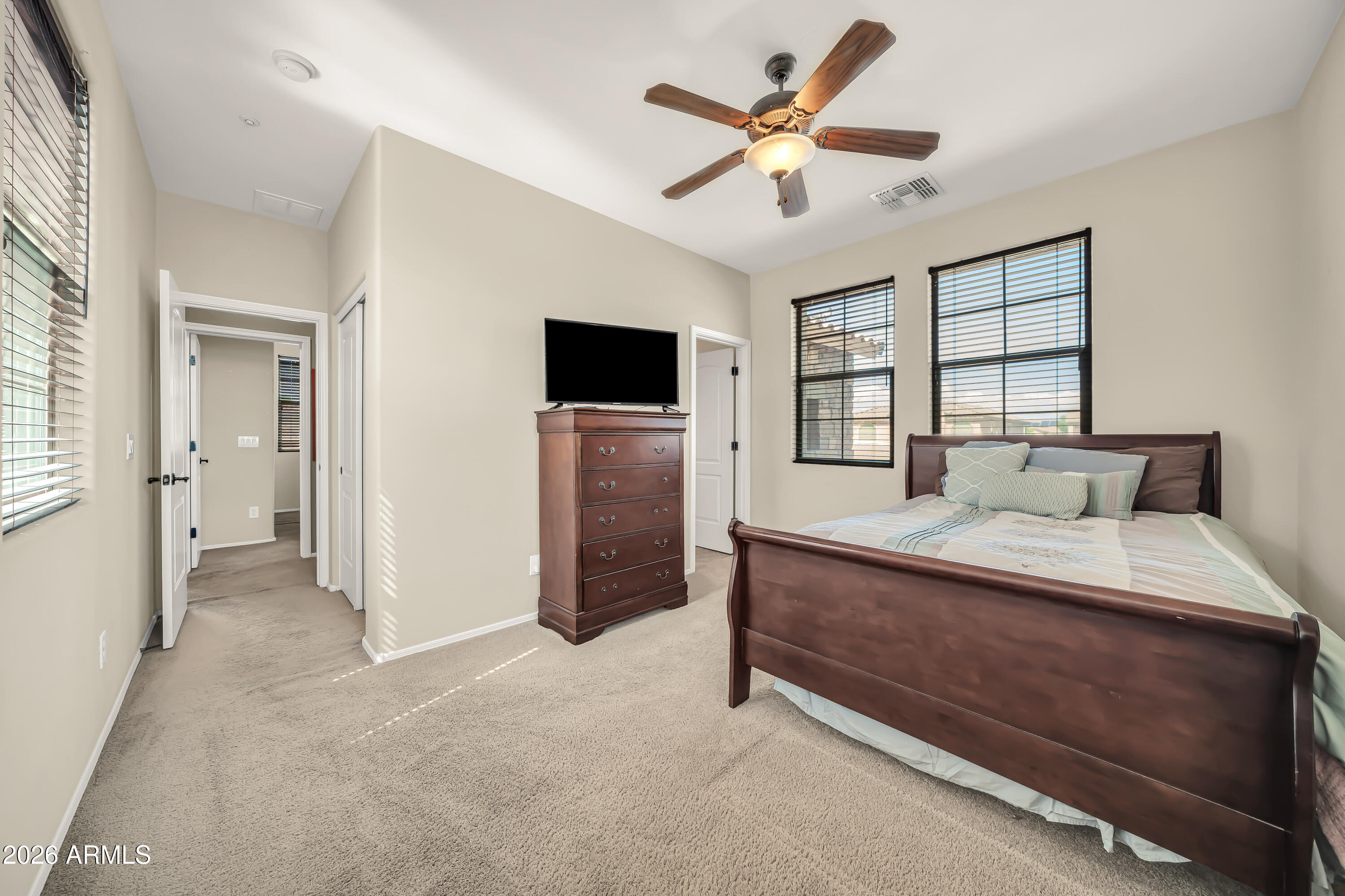 15327 West Roma Avenue Goodyear, AZ 85395 - Photo 40 of 65 a spacious bedroom with a bed and a television