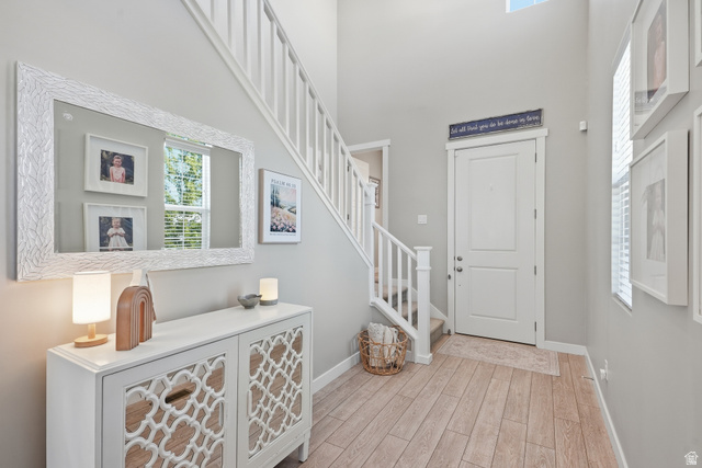 3244 West 1670th Street North Provo, UT 84601 - Photo 6 of 56 Bright entry hall featuring a tall ceiling, wood-finish flooring, and a white paneled door