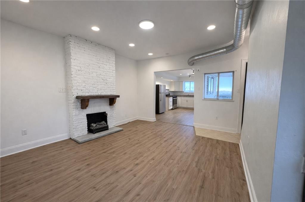 1921 Shamokin Street Pittsburgh, PA 15203 - Photo 2 of 10 an empty room with wooden floor fireplace and windows