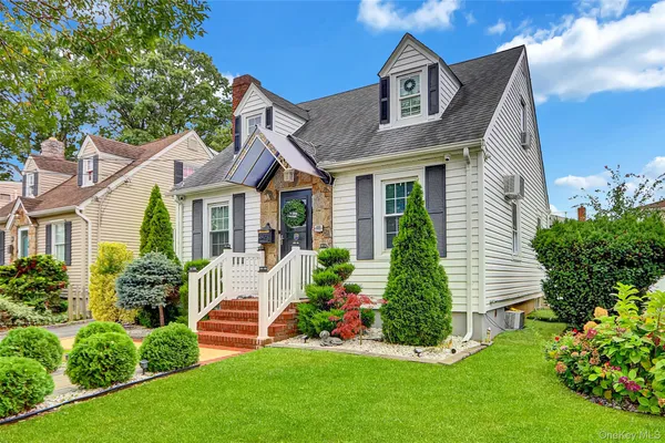 a front view of a house with a garden and plants