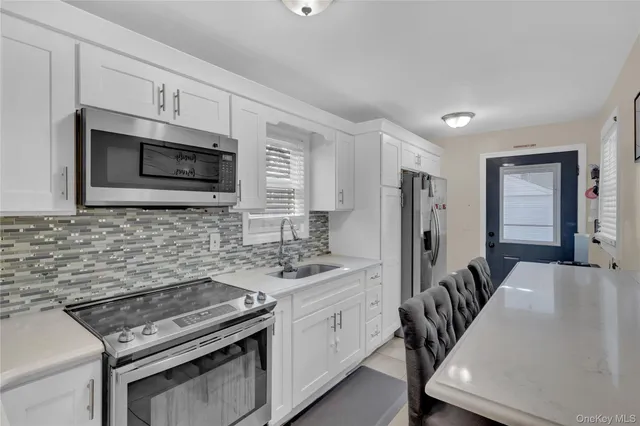 a kitchen with stainless steel appliances a stove microwave sink refrigerator and cabinets