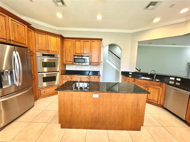 a large kitchen with kitchen island granite countertop a large counter top stainless steel appliances and cabinets