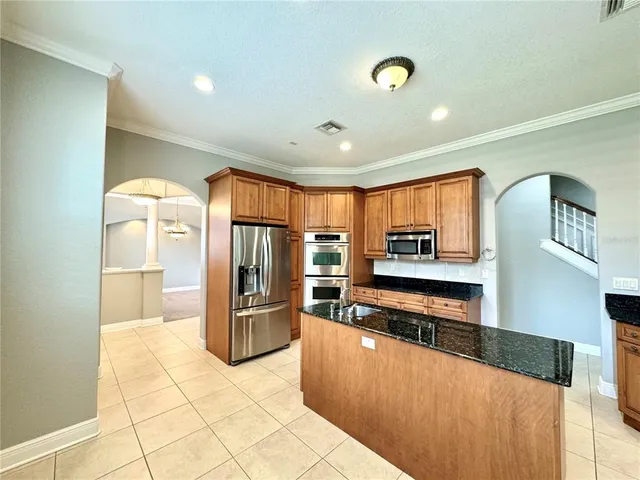 a large kitchen with stainless steel appliances a refrigerator and a stove top oven