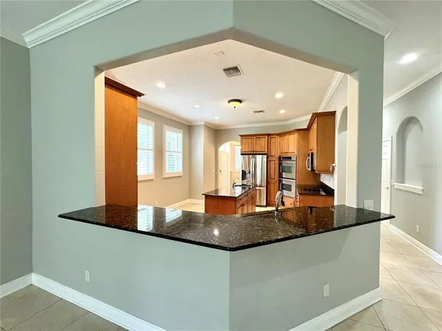 a large kitchen with kitchen island granite countertop a large window