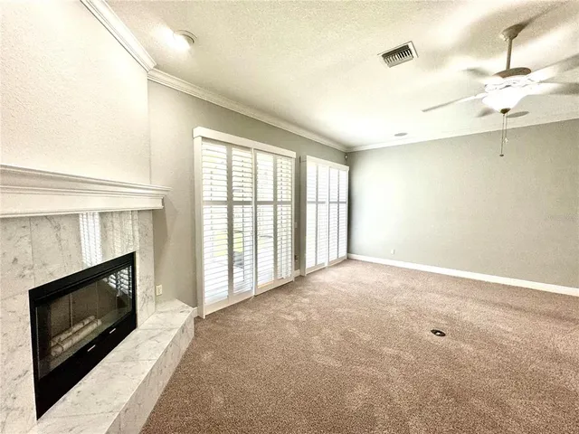 a view of an empty room with a fireplace and a window