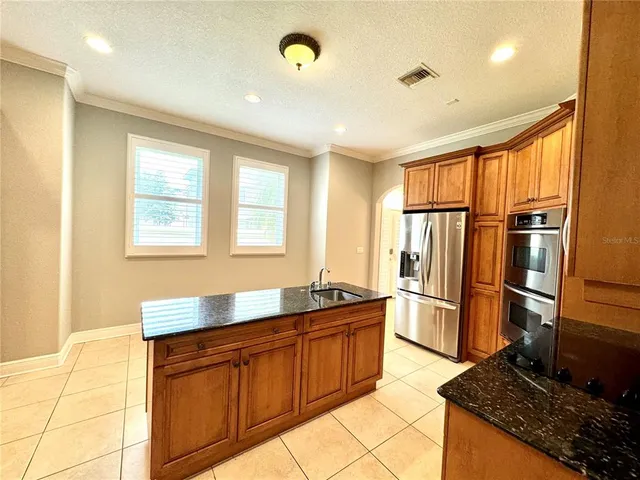 a kitchen with stainless steel appliances granite countertop a refrigerator and a sink