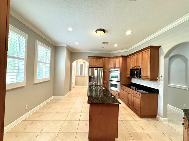 a large kitchen with stainless steel appliances granite countertop a stove and cabinets