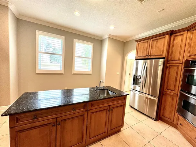 a kitchen with stainless steel appliances granite countertop a refrigerator and a sink