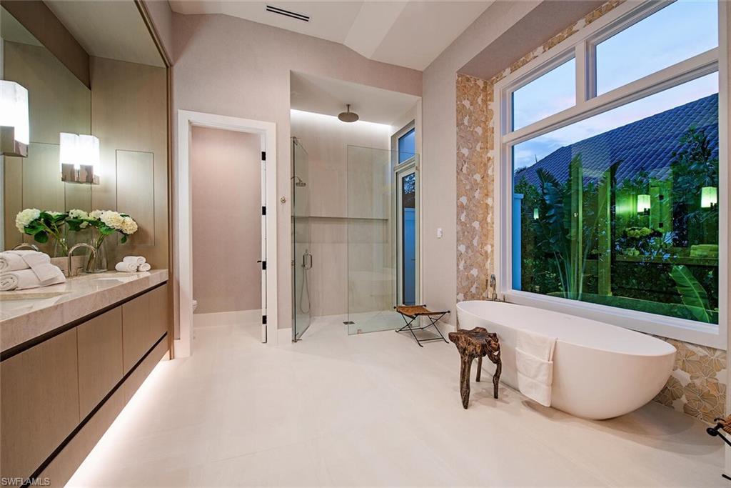 2999 Rum Row Naples, FL 34102 - Photo 17 of 33 Bathroom with a shower stall, vanity, a freestanding bath, toilet, and visible vents