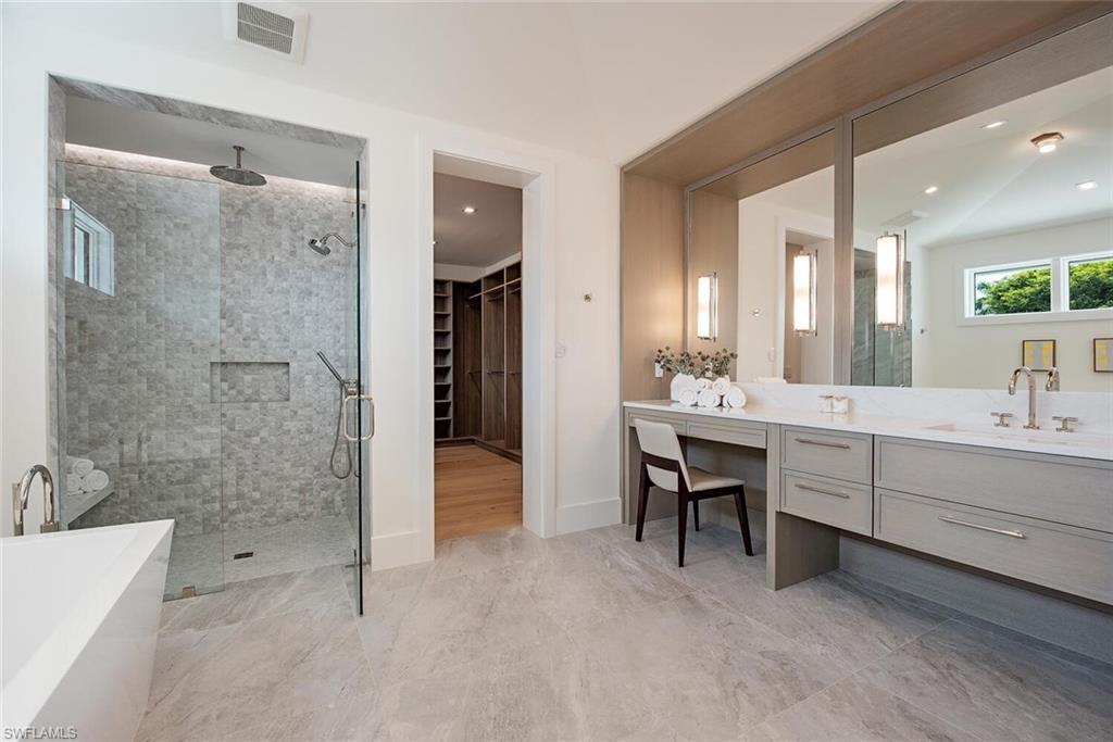 2999 Rum Row Naples, FL 34102 - Photo 18 of 33 Full bath with a spacious closet, visible vents, vanity, a freestanding tub, and a stall shower