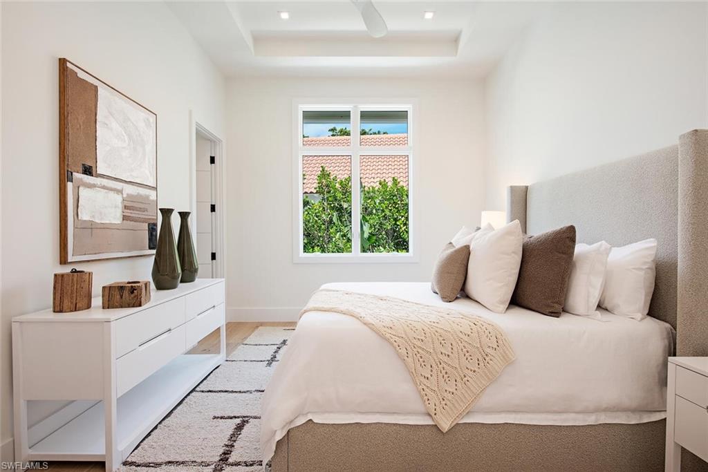 2999 Rum Row Naples, FL 34102 - Photo 22 of 33 Bedroom featuring baseboards, light wood finished floors, and a raised ceiling