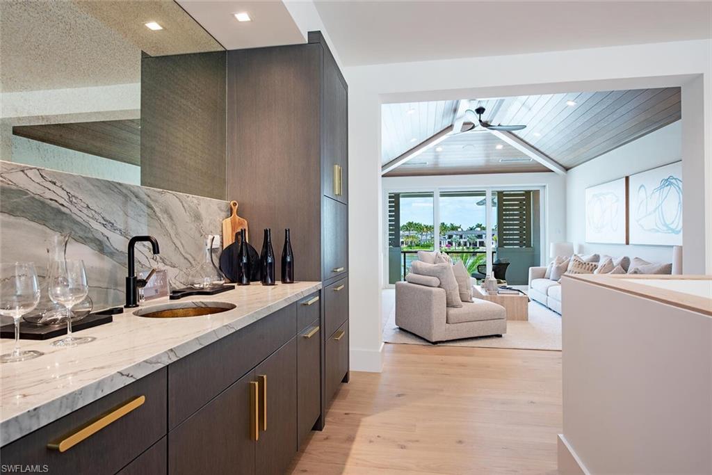 2999 Rum Row Naples, FL 34102 - Photo 23 of 33 Bar with a sink, tasteful backsplash, light wood-type flooring, wet bar, and recessed lighting
