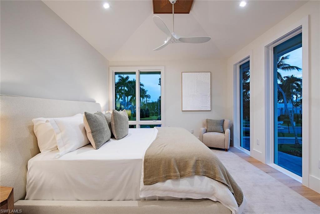 2999 Rum Row Naples, FL 34102 - Photo 27 of 33 Bedroom featuring recessed lighting, lofted ceiling, access to exterior, and light wood-type flooring