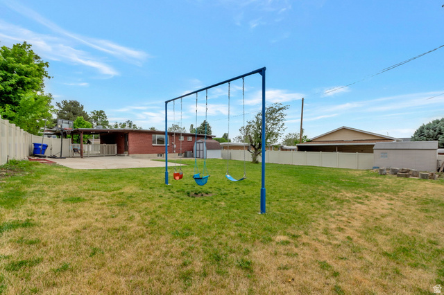 447 550 South Bountiful, UT 84010 - Photo 24 of 25 Expansive backyard featuring a grass lawn, a paved patio, and a privacy fence