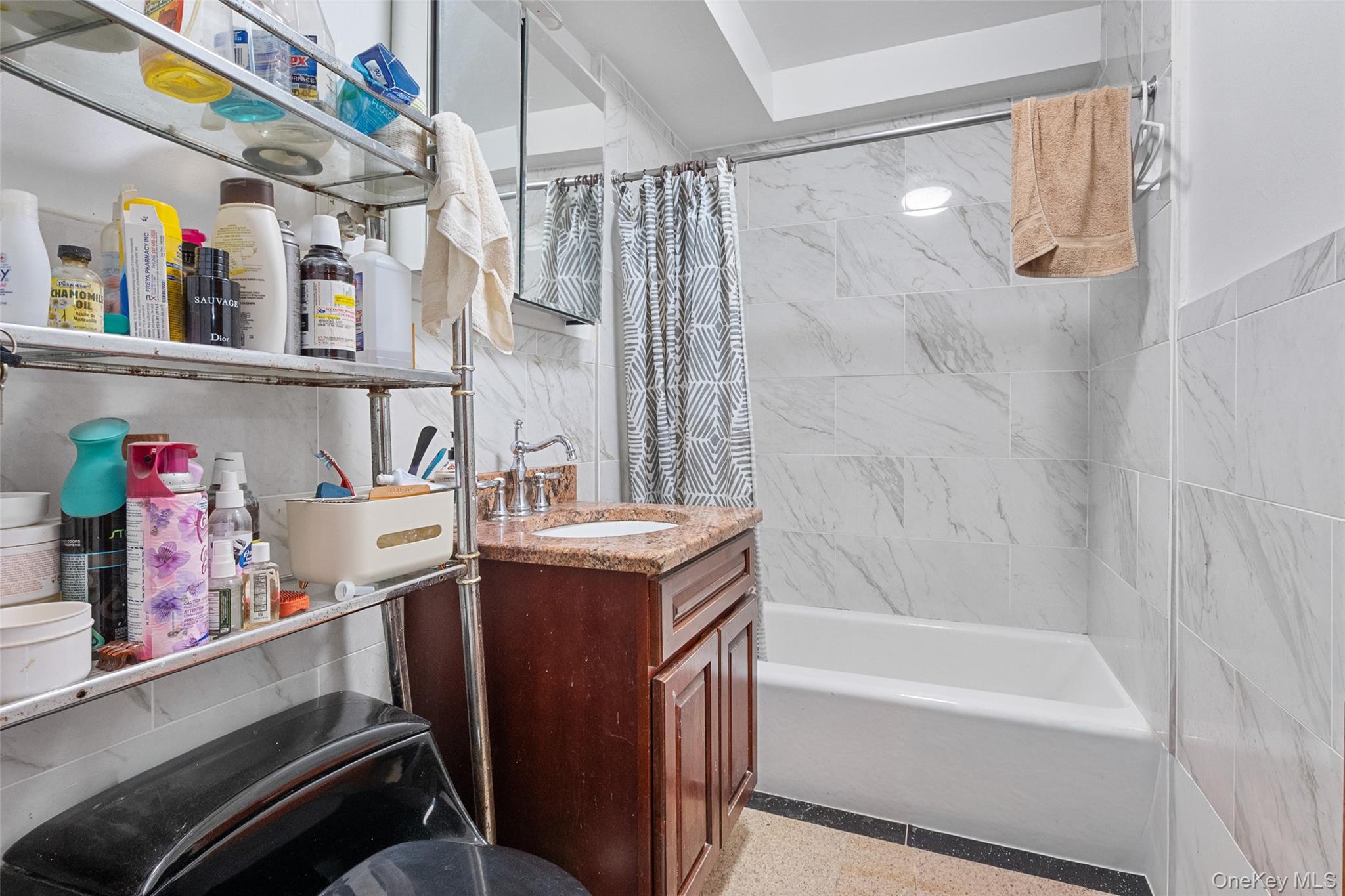 108-10 35th Avenue Queens, NY 11368 - Photo 22 of 29 Bathroom with shower / bath combo, tile walls, and vanity