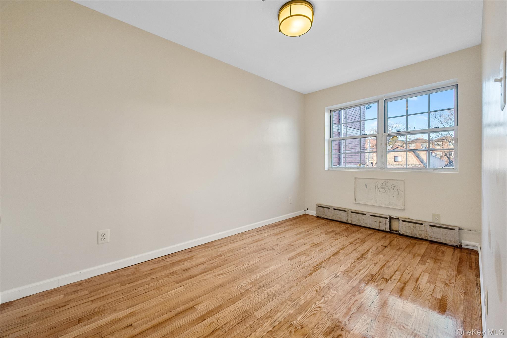 108-10 35th Avenue Queens, NY 11368 - Photo 26 of 29 Unfurnished room featuring light wood-style flooring and a baseboard radiator
