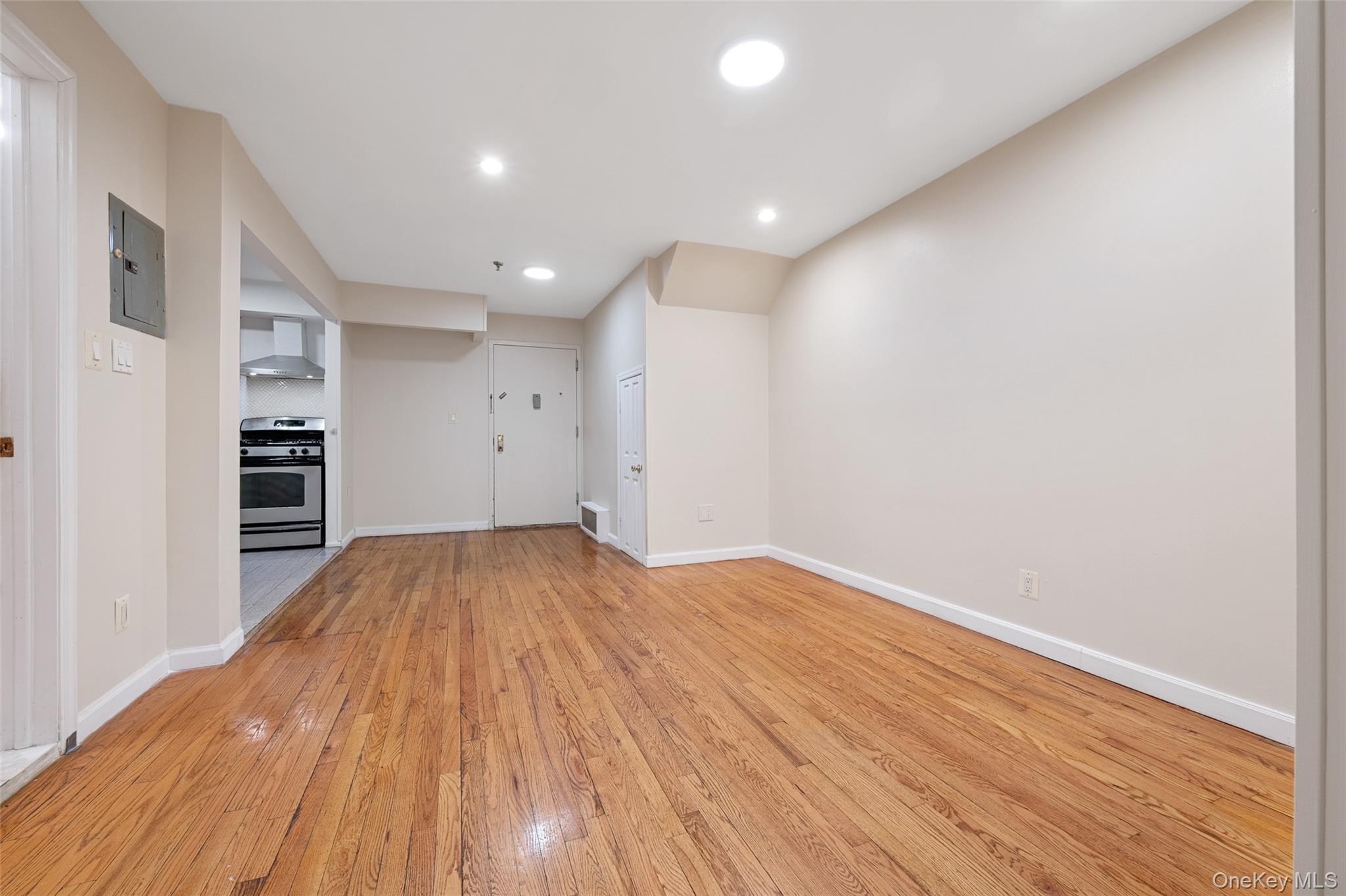 108-10 35th Avenue Queens, NY 11368 - Photo 4 of 29 Unfurnished living room with light wood-style floors, electric panel, and recessed lighting