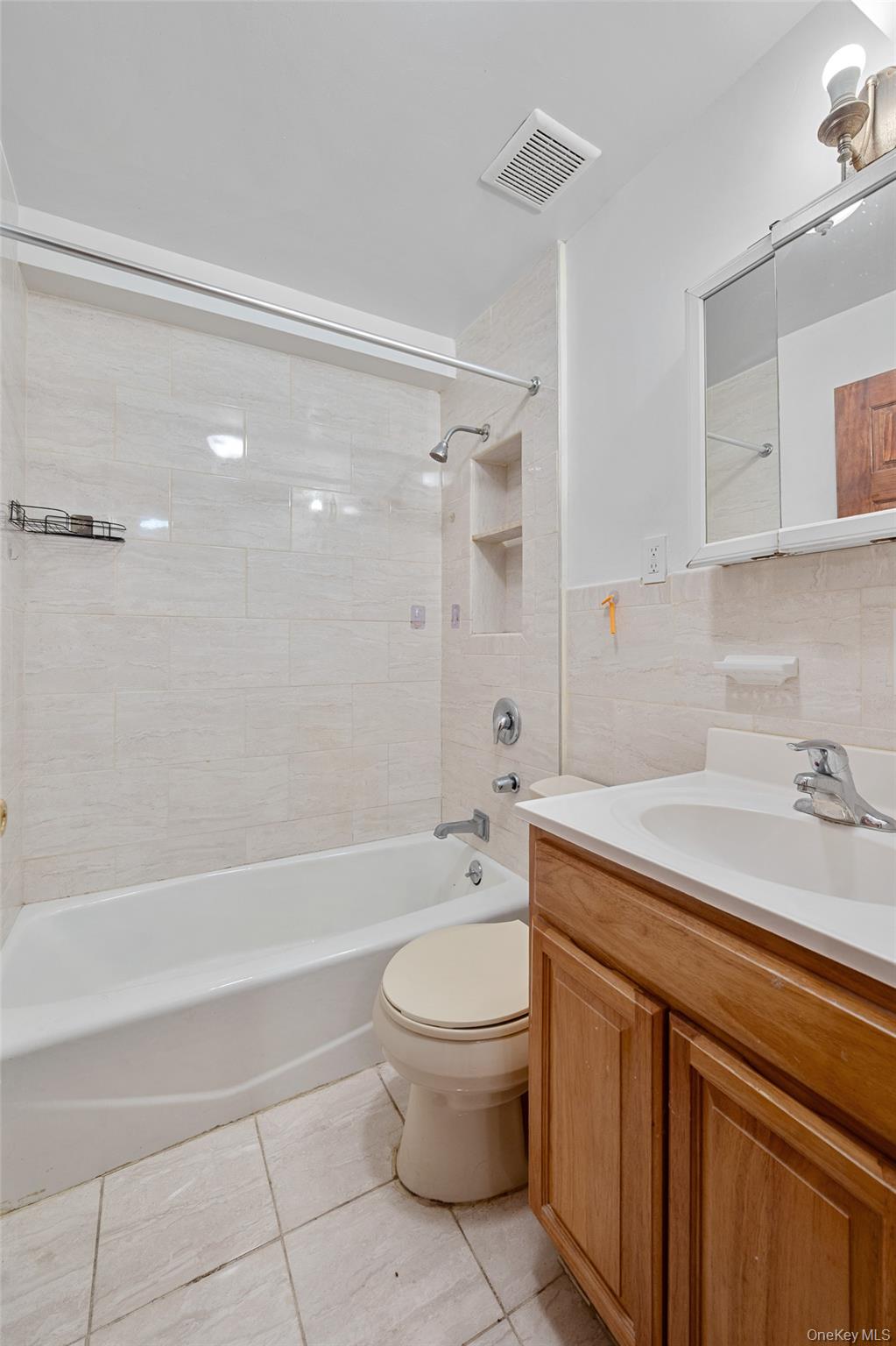 108-10 35th Avenue Queens, NY 11368 - Photo 8 of 29 Bathroom featuring vanity, shower / bath combination, tile walls, and light tile patterned floors