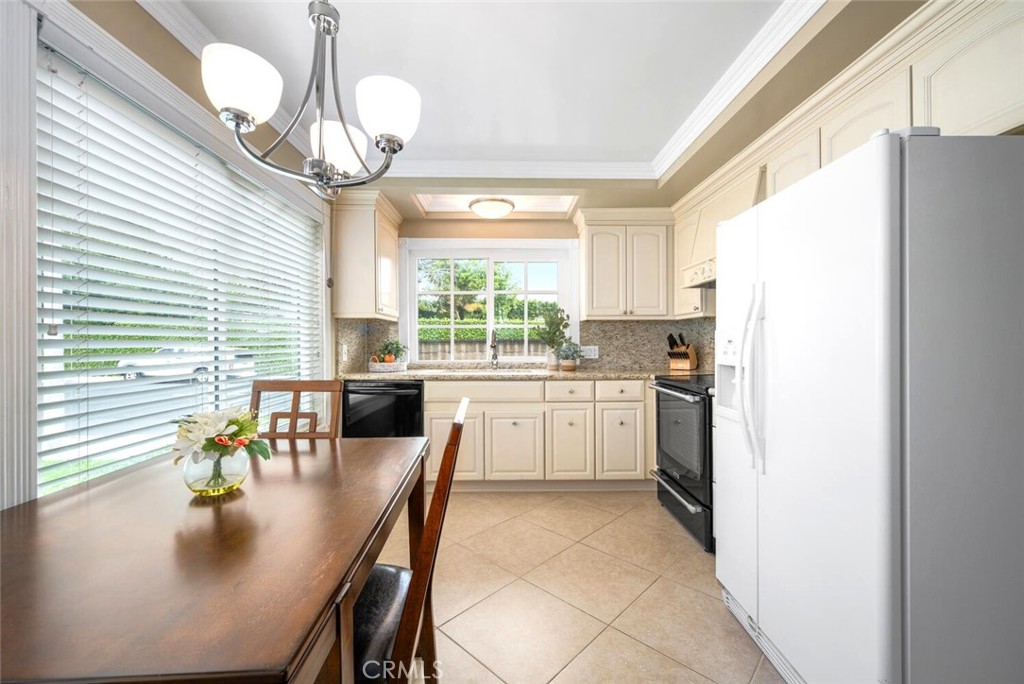 11253 Gardiners Court Cypress, CA 90630 - Photo 25 of 74 a kitchen with a table chairs stove and refrigerator