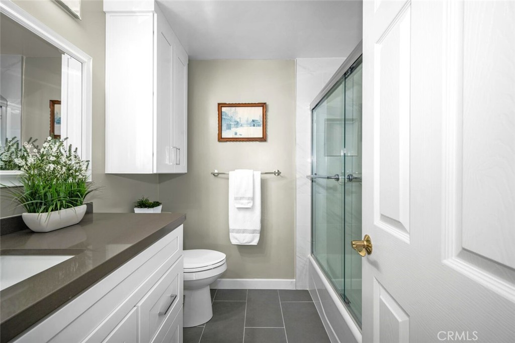 11253 Gardiners Court Cypress, CA 90630 - Photo 52 of 74 a bathroom with a granite countertop sink a toilet and shower