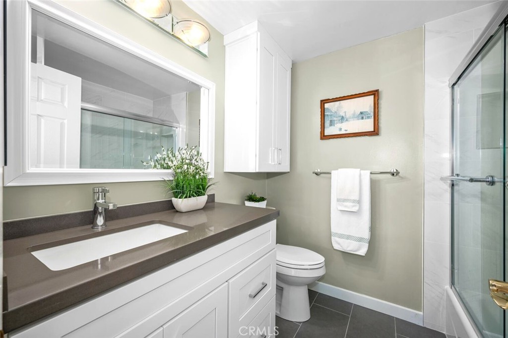 11253 Gardiners Court Cypress, CA 90630 - Photo 53 of 74 a bathroom with a sink a toilet and a mirror