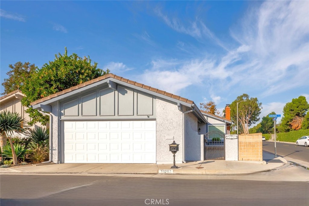 11253 Gardiners Court Cypress, CA 90630 - Photo 6 of 74 a front view of a house with a yard and garage