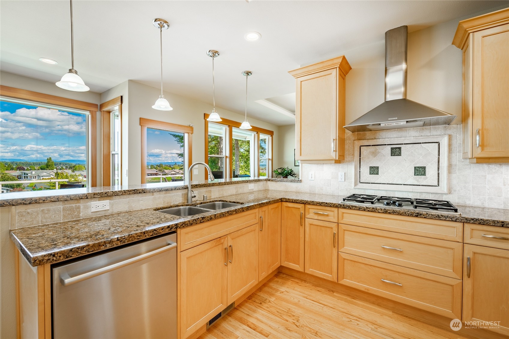 8148 Comox Road Blaine, WA 98230 - Photo 11 of 40 a kitchen with stainless steel appliances granite countertop a sink a stove and a wooden floor
