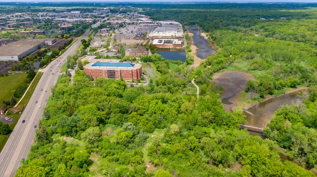 an aerial view of residential houses with outdoor space and trees
