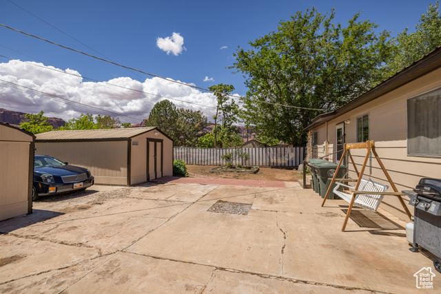 527 Palisade Drive Moab, UT 84532 - Photo 28 of 51 View of patio / terrace with a storage unit, a fenced backyard, and an outdoor structure