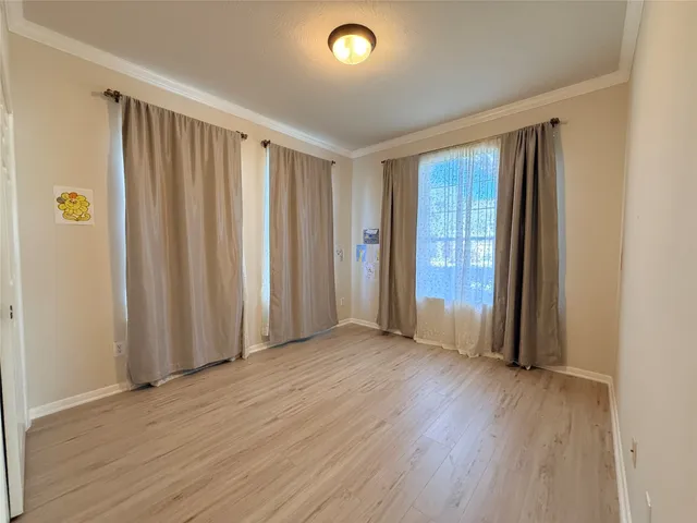 an empty room with wooden floor and a window